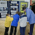 three children and a woman looking at a display