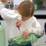 Pupil making composter from plastic bottle